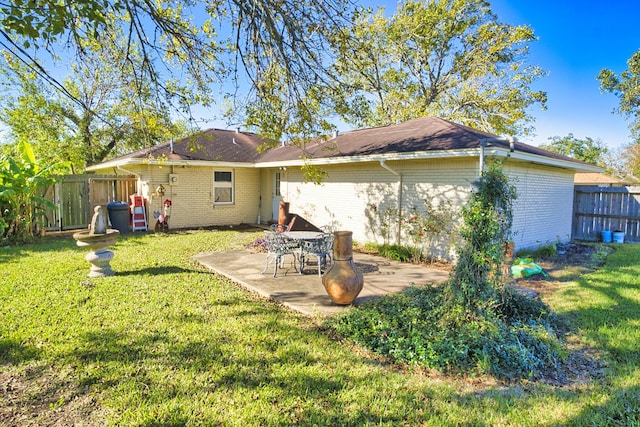 back of house with a yard and a patio