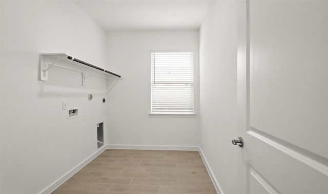 clothes washing area featuring gas dryer hookup, hookup for an electric dryer, washer hookup, and light hardwood / wood-style floors