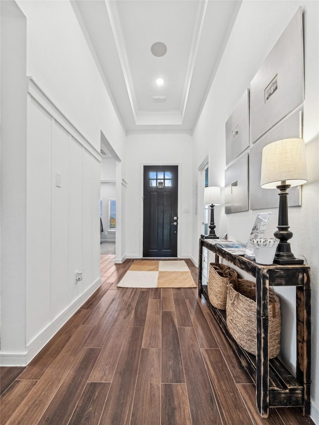 foyer entrance with crown molding and a tray ceiling