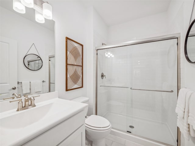 bathroom featuring tile patterned flooring, vanity, an enclosed shower, and toilet