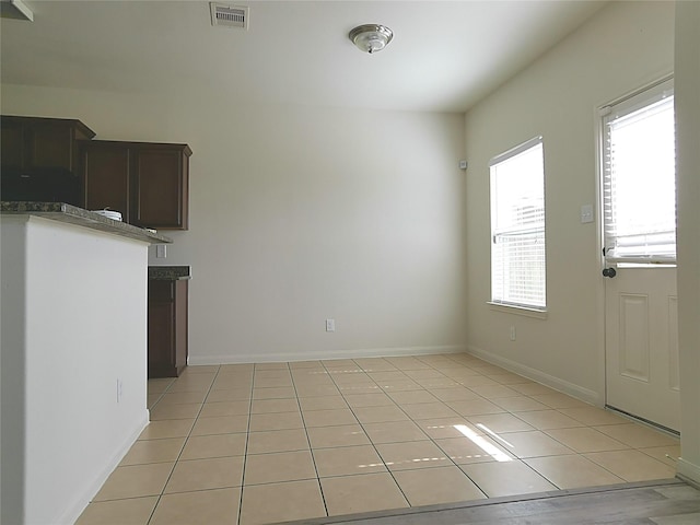 unfurnished dining area featuring plenty of natural light and light tile patterned floors