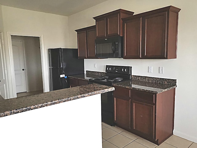 kitchen with black appliances, dark brown cabinets, light tile patterned floors, and dark stone counters