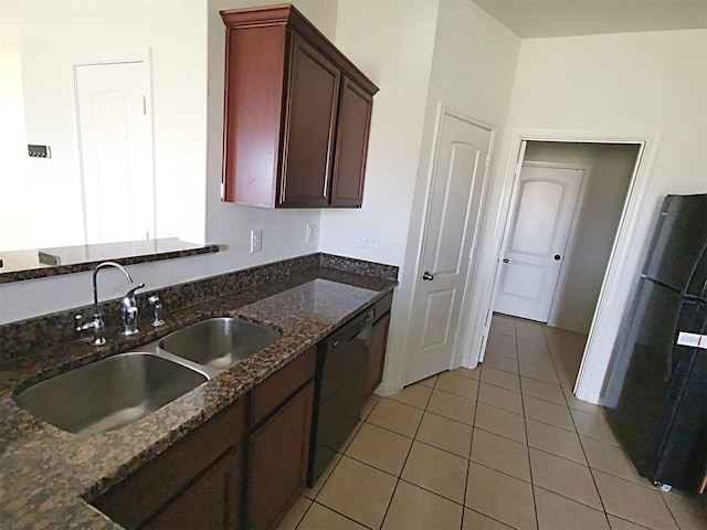 kitchen featuring black appliances, dark stone countertops, light tile patterned floors, and sink