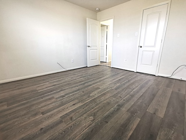 unfurnished bedroom with dark wood-type flooring