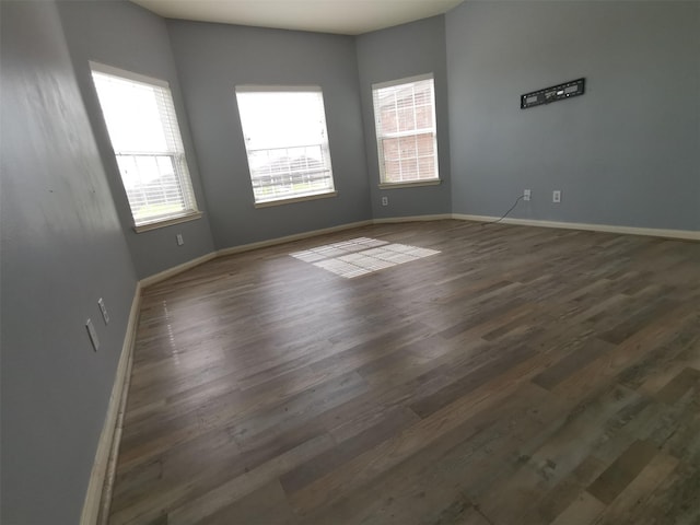 unfurnished room with dark hardwood / wood-style floors and a wealth of natural light