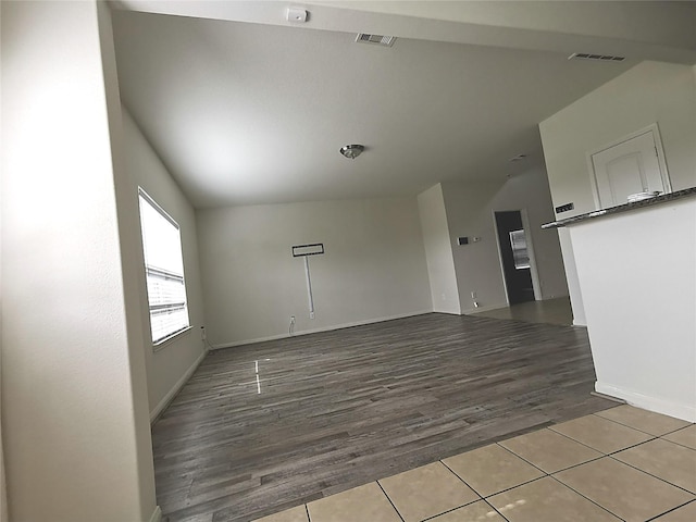 unfurnished room featuring hardwood / wood-style floors and vaulted ceiling