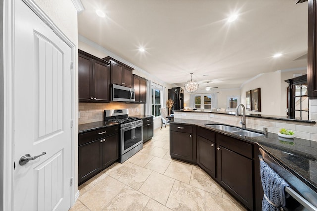 kitchen featuring decorative backsplash, dark brown cabinetry, stainless steel appliances, ceiling fan with notable chandelier, and sink