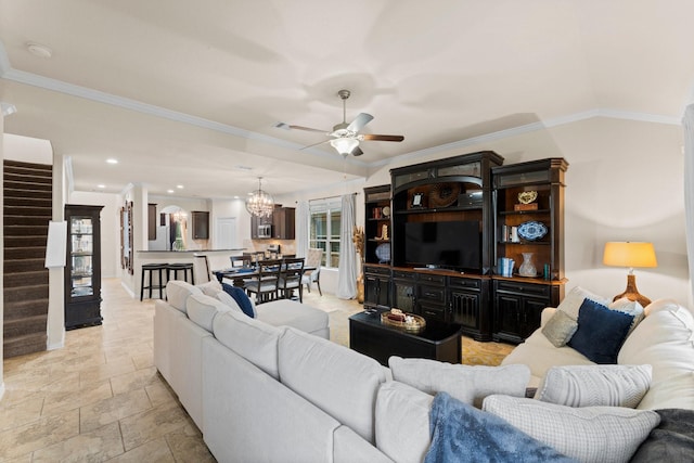 living room with ceiling fan with notable chandelier and ornamental molding