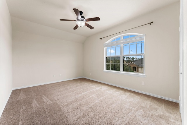 carpeted spare room featuring ceiling fan and lofted ceiling