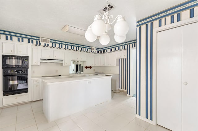 kitchen featuring pendant lighting, black appliances, white cabinets, a kitchen island, and a chandelier