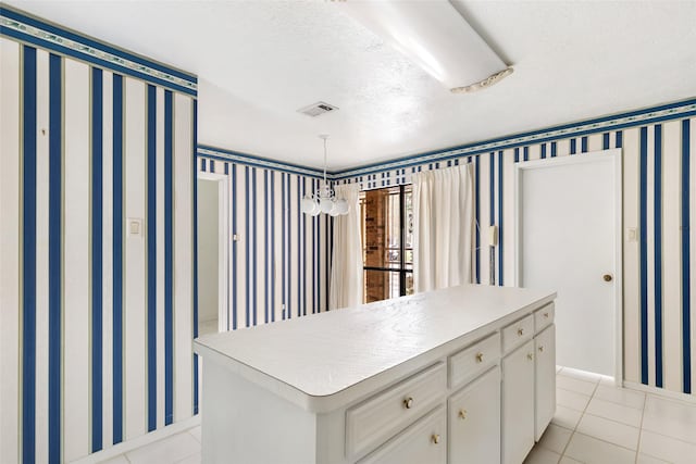 walk in closet with a notable chandelier and light tile patterned flooring