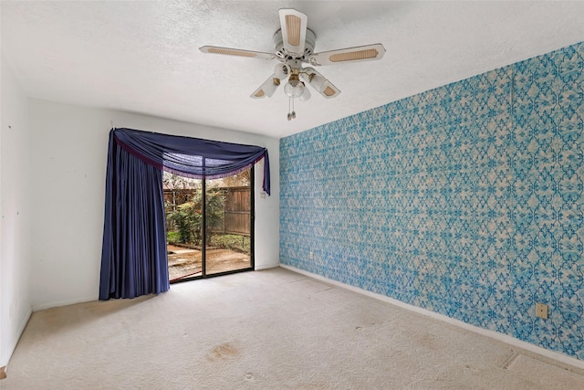 carpeted spare room with ceiling fan and a textured ceiling