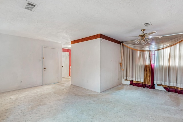 empty room with carpet flooring, ceiling fan, and a textured ceiling