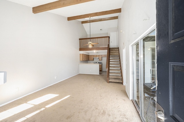 unfurnished living room featuring beam ceiling, light colored carpet, and high vaulted ceiling