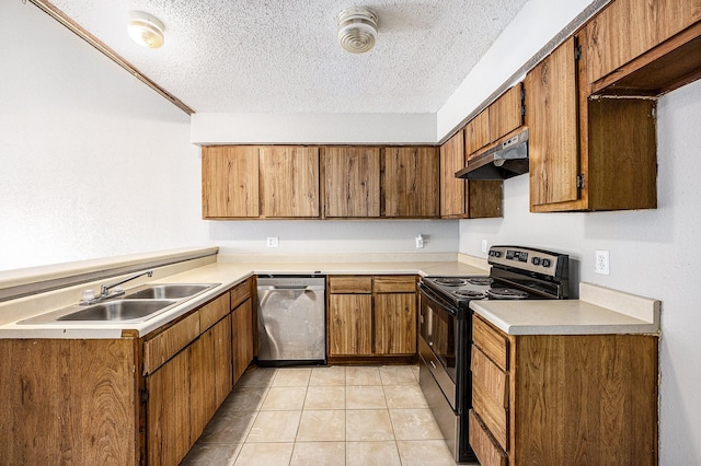 kitchen featuring sink, light tile patterned floors, a textured ceiling, and appliances with stainless steel finishes