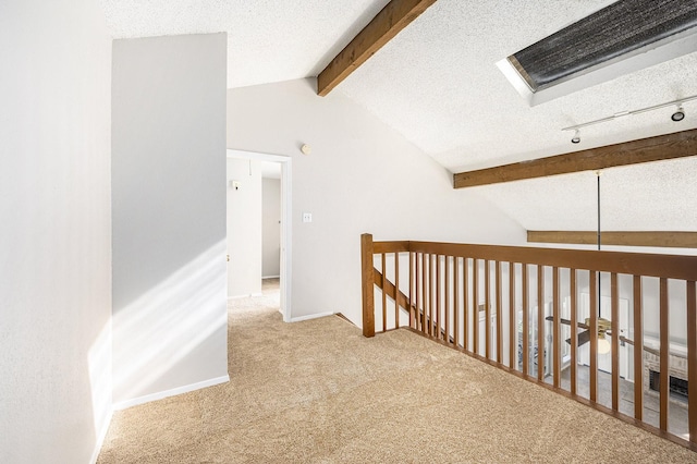 hall with carpet flooring, a textured ceiling, and lofted ceiling with beams