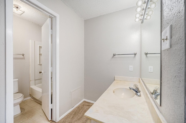 bathroom featuring tile patterned floors, vanity, a textured ceiling, and toilet