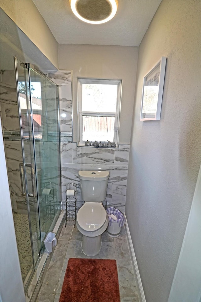 bathroom with toilet, an enclosed shower, and tile walls