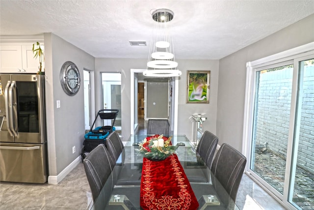 dining area featuring a chandelier and a textured ceiling