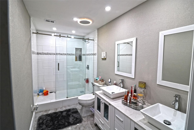 bathroom with a shower with door, vanity, and toilet