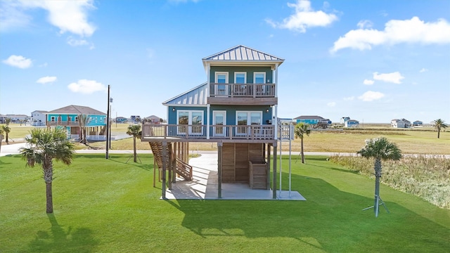 4003 Mitote Dr, Galveston, TX 77554 - back of property featuring a yard, a standing seam roof, a wooden deck, stairway, and a balcony