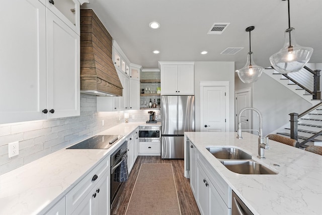 4003 Mitote Dr, Galveston, TX 77554 - kitchen featuring appliances with stainless steel finishes, a sink, premium range hood, recessed lighting, and dark wood-style floors