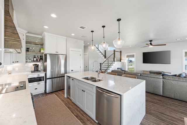 kitchen featuring white cabinetry, sink, light stone countertops, and appliances with stainless steel finishes