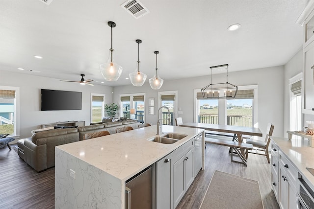 4003 Mitote Dr, Galveston, TX 77554 - kitchen with a sink, dark wood finished floors, recessed lighting, white cabinets, and a center island with sink