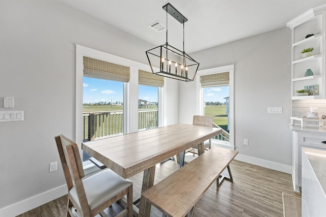 dining space featuring dark wood-type flooring and an inviting chandelier