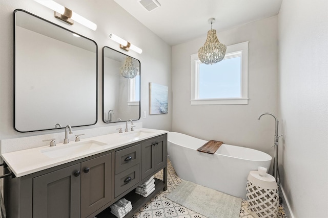 bathroom featuring a chandelier, vanity, and a bathing tub