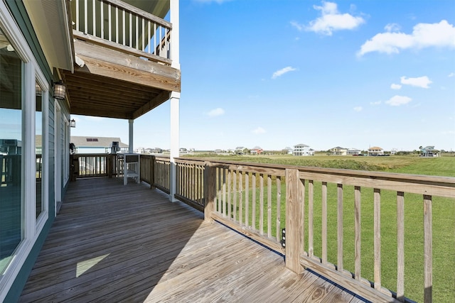 wooden terrace featuring a lawn