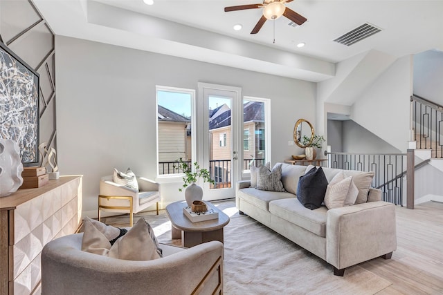 living room with light hardwood / wood-style floors and ceiling fan