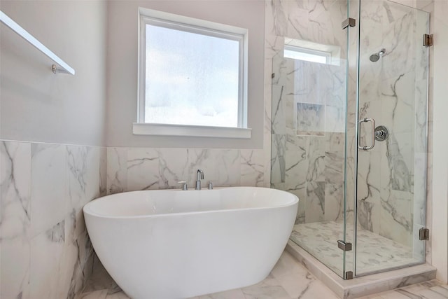 bathroom featuring plus walk in shower and tile walls