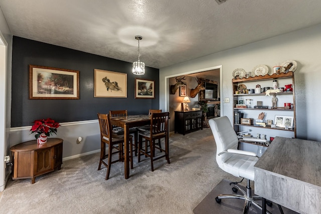 dining space with carpet, a chandelier, and a textured ceiling