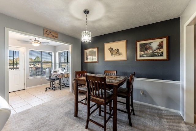 dining room with ceiling fan, light carpet, and a textured ceiling