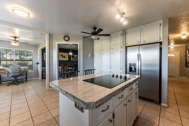 kitchen with a center island, stainless steel fridge with ice dispenser, a textured ceiling, and black electric cooktop