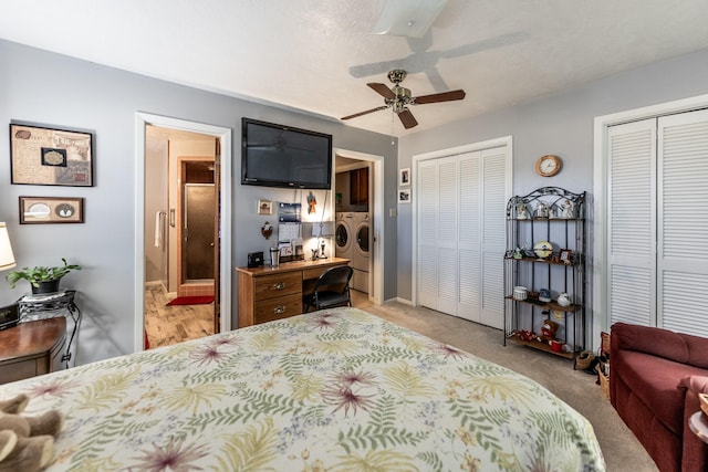 carpeted bedroom with a textured ceiling, ceiling fan, two closets, and independent washer and dryer