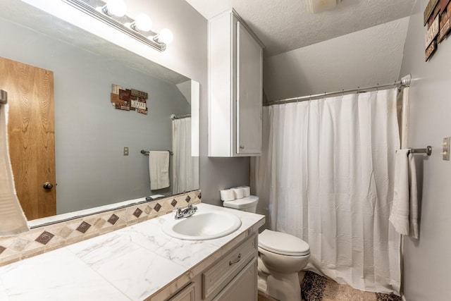 bathroom featuring vanity, a textured ceiling, and toilet