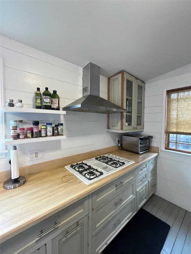 kitchen featuring wooden counters, white gas cooktop, wall chimney range hood, hardwood / wood-style floors, and gray cabinets