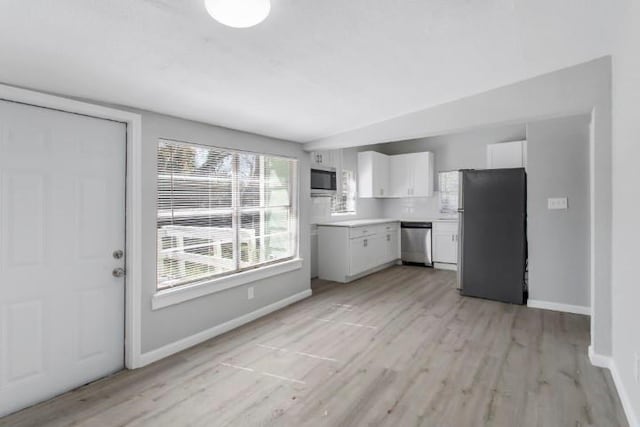 kitchen with light wood-type flooring, white cabinetry, and stainless steel appliances