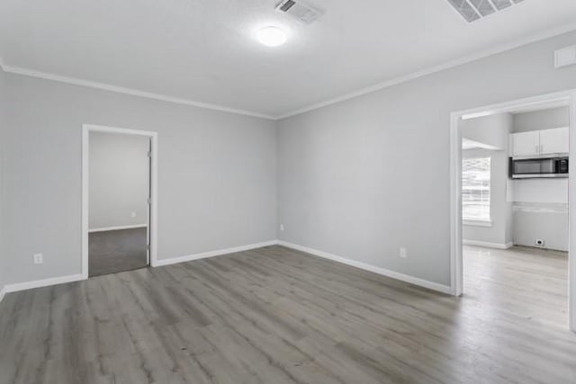 empty room featuring light hardwood / wood-style floors and ornamental molding