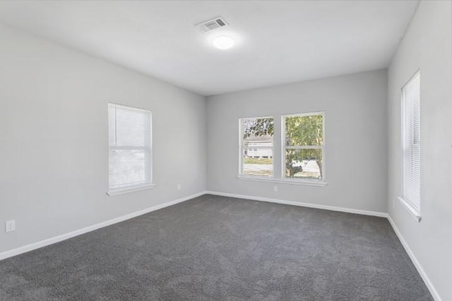 spare room featuring dark carpet