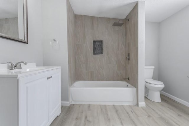 full bathroom featuring hardwood / wood-style floors, vanity, tiled shower / bath combo, and toilet