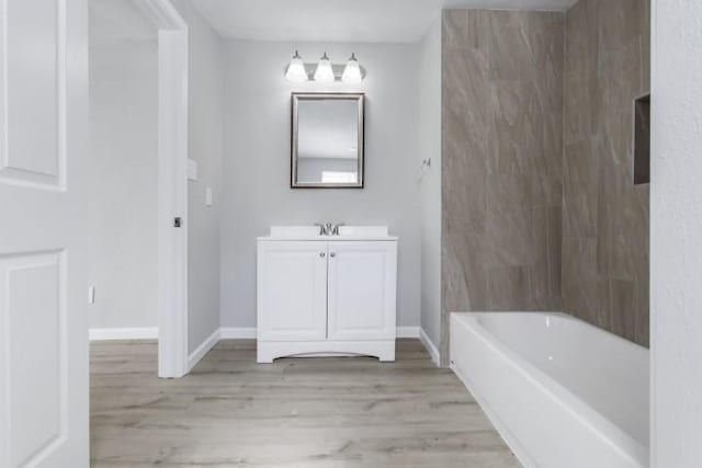 bathroom with hardwood / wood-style flooring, vanity, and shower / bath combination