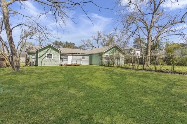 rear view of property featuring a lawn