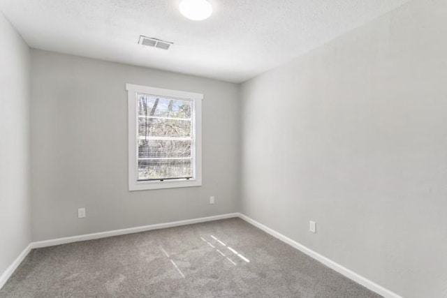 carpeted spare room with a textured ceiling