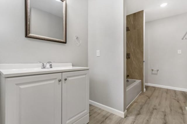 bathroom with hardwood / wood-style floors, vanity, and shower / bathing tub combination