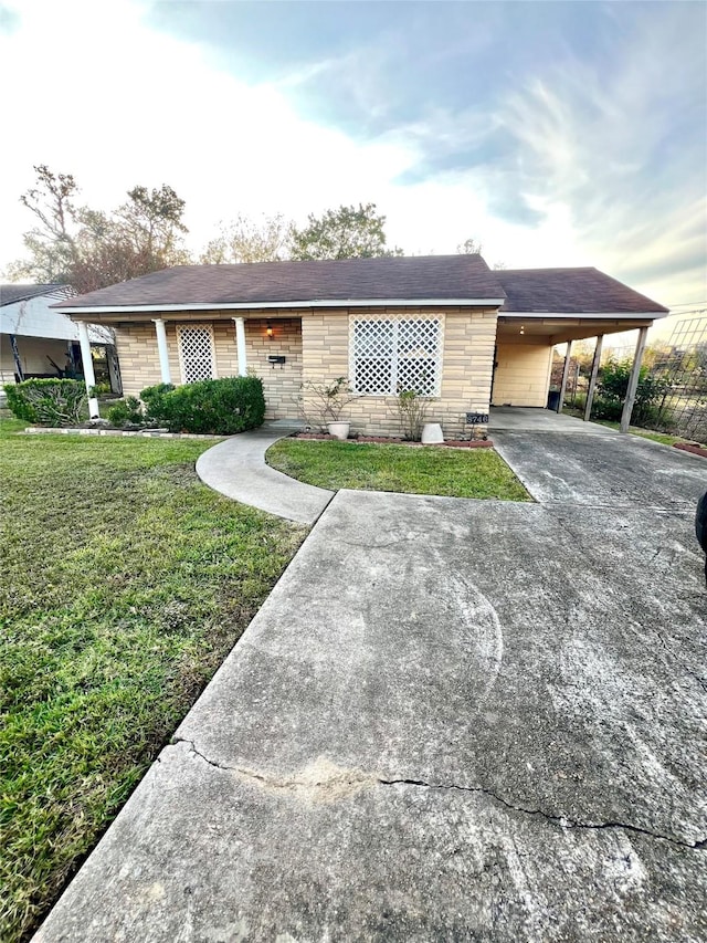 single story home featuring a front lawn and a carport