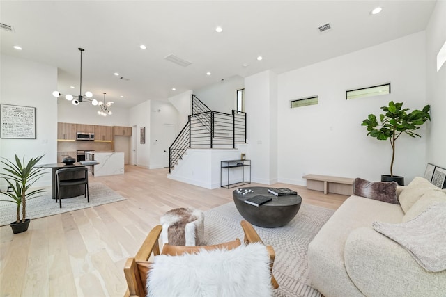 living room featuring a notable chandelier and light wood-type flooring