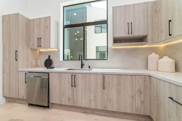 kitchen featuring tasteful backsplash, light brown cabinetry, sink, and stainless steel dishwasher